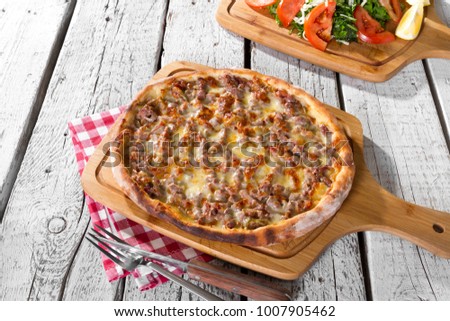 Delicious Traditional Turkish and Arabic Ramadan Baked Pide or Pizza ingredients with sliced lamb beef, mozzarella cheese and spicy herbs on rustic white wood background. Copy space for text area.