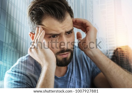 Bad thoughts. Deep serious unshaken man looking aside feeling bad himself and touching to his head. Royalty-Free Stock Photo #1007927881