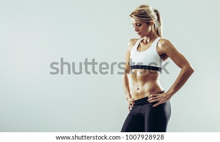 Young healthy athlete woman with perfect body posing in front of camera. Young healthy athlete female posing against white background Royalty-Free Stock Photo #1007928928