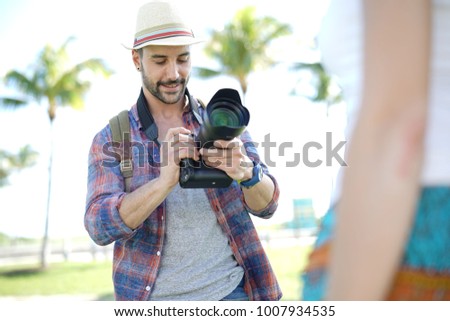 Photographer taking pictures of model in park