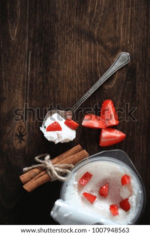 Yoghurt with fresh juicy strawberries and cherries on a wooden table
