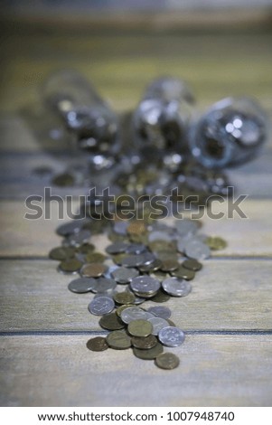 Accumulated coins stacked in glass jars on the floor