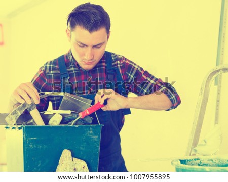 Handyman searching in his toolbox for necessary tools