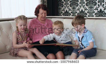 Close-up of grandmother with grandchildren watching the photo album at home.