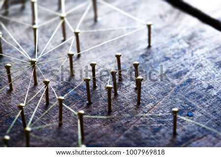 Connecting people and devices. Networking, social media, SNS, internet infrastructure communication abstract. Small or private network connected to a social network. Web of gold wires on rustic wood.