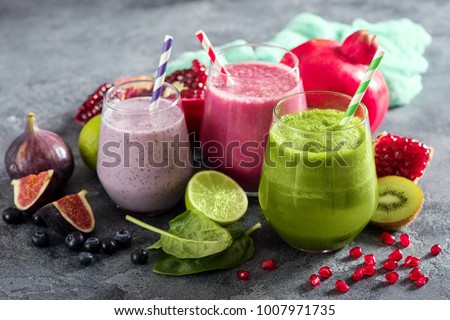 Colorful smoothie, healthy detox vitamin diet or vegan food concept, fresh vitamins, breakfast drink with spinach, pomegranate, figs and blueberries Royalty-Free Stock Photo #1007971735
