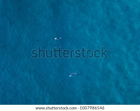 Aerial view of group of surfers relaxing in the water.