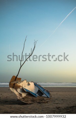 close up of ship boat wreck isolated on sandy beach in beautiful sunrise, basque country, france