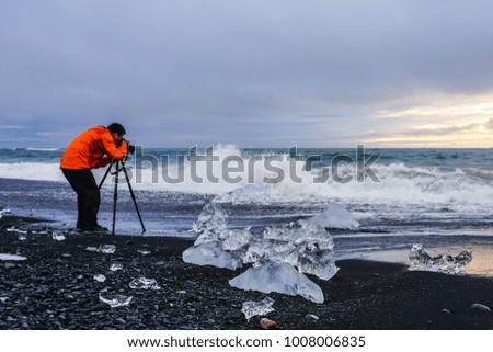 Man photographer at Jokulsarlon glacier lake lagoon. Vatnajokull National Park. Iceland.