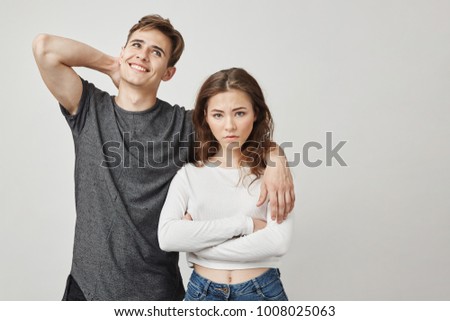 Photo of dissapointed girlfriend and boyfriend who do not care. Woman is concerned about relationship with this guy. He thinks only about himself. Maybe there is hope and he will change. Royalty-Free Stock Photo #1008025063