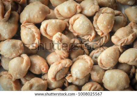 Kanom Pun-Sib . Thai dessert made from wheat flour look like curry puff, but smaller with many filling such as pork, chicken, pineapple and bean. Use medium heat 20 minuets till become golden brown.  Royalty-Free Stock Photo #1008025567