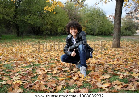 An outdoor portrait of a handsome curly boy in a park