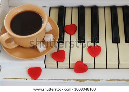 Red hearts and a cup of coffee are decorated with piano keys. Valentine's Day .