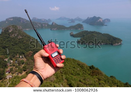 Hand of Rescue  with radio communications on the mountain ocean and island background at ang thong Thailand.