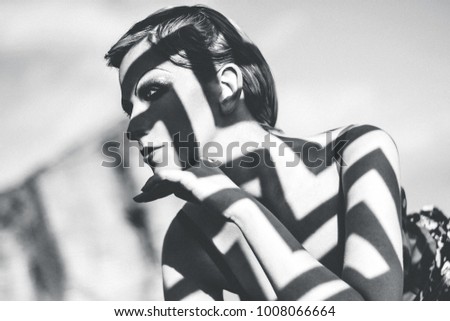 Close up vintage creative portraite of russian girl with shadow from the grate on her body