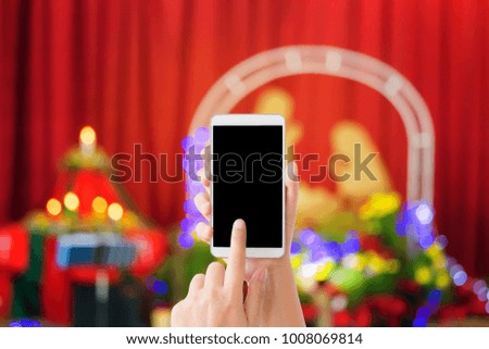 woman use mobile phone and blurred image of the church in Christmas celebration