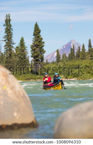 Couple paddling the whitewater of the Nahanni River in the Northwest Territories.