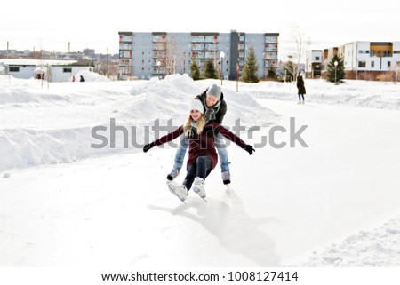 couple in sunny winter nature ice skating