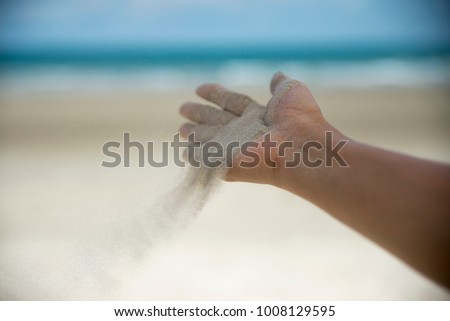 Let it go, Freedom hand , and Release concept. Hand let go of woman release sand on beautiful sea beach and blue water background Royalty-Free Stock Photo #1008129595
