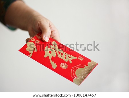 Hands give red envelope " Ang pao ", chinese new year concept .Chinese word mean " Happy "