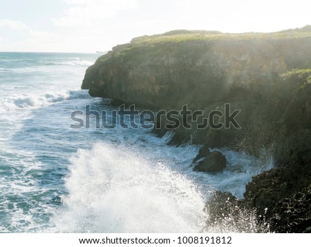 Waves of the ocean are breaking against the rocks