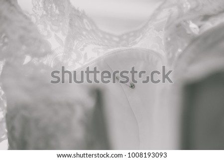 Safety pin on wedding dress. Horizontal color photography.