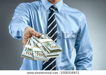 Man in blue shirt holding cash of one hundred dollars. Close up. Business concept