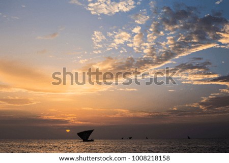 Traditional Zanzibar dhow at sunset. Beautiful sunset sky and the dhow in the sea at Zanzibar, Tanzania