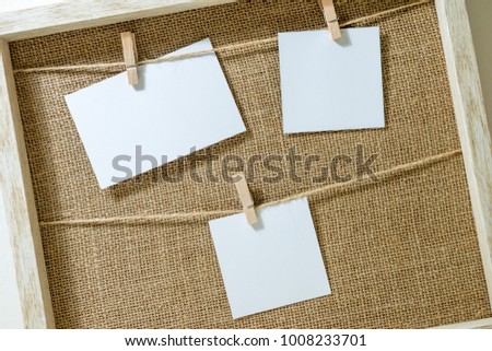 Empty Three Photo Frames on Rope inside the wooden frame
