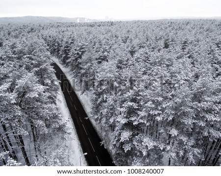 Aerial top view of road in winter forest