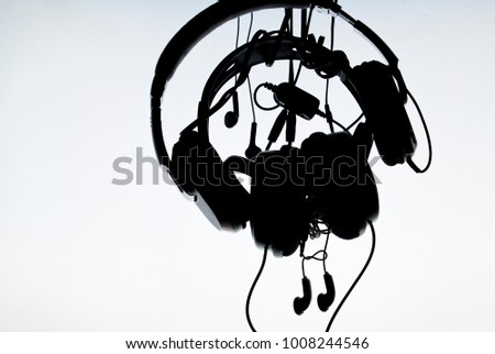 Silhouette a headphones with striped wires on a white gradient background
