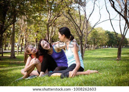 Happy daughter and mother are smiling, relaxing and talking on a grass in the green park with sport wear. Happy family time in holiday for health. vintage tone.