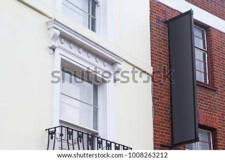 Horizontal side view of empty black long stripe signage on a British building with classical architecture