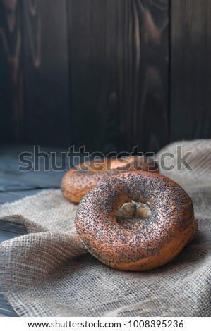 Fresh bagel with poppy seed on sackcloth. Russian traditional bakery product. or bakery pastry banner, ad, poster.