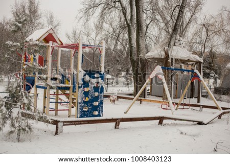 Playground in winter. Winter is a nuisance for children. The snow on the playing apparatus.