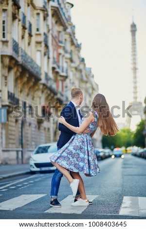 Romantic couple kissing on the street with Eiffel tower in background in Paris, France