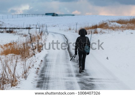 Tourist with a tripod. Winter landscape at Godoya Island near Alesund, Norway