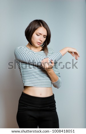 Business woman has pain in the elbow joint, isolated on background, studio photo