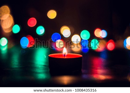 Candle flame light at night with bokeh on dark background
