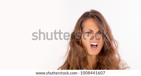 A frustrated and angry girl screaming; isolated on white, copy space photo