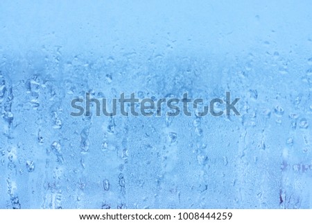 Humidity on a window with blurred background. Texture of water droplets on glass