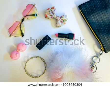 Flatlay photography of handbags with various accessories spilling out in pink tones