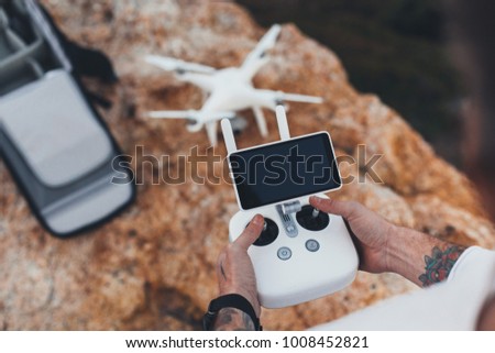 Stock aerial video creator and photographer prepares drone for flight, sets up controls and remote connection, easy how to steps to learn drone instructions for amateurs and professionals