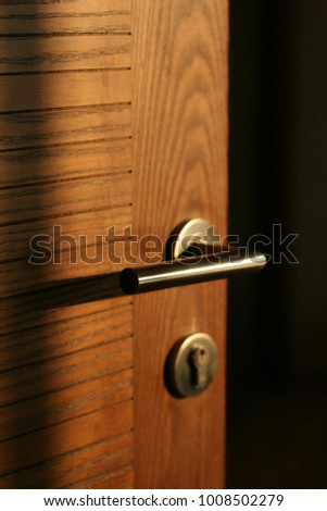 Wooden door open with door handle and security lock Royalty-Free Stock Photo #1008502279