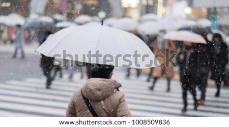 Out of focus or blurred images of people walking in rare snow storm in Tokyo.