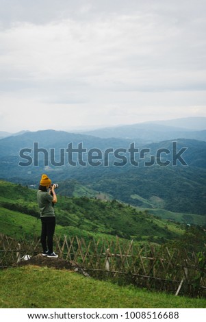 Woman talking picture of landscape on Doi Chang Moob viewpoint. This place locateed in Chiang Rai, Thailand.