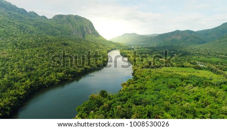 Beautiful natural scenery of river in southeast Asia tropical green forest  with mountains in background, aerial view drone shot Royalty-Free Stock Photo #1008530026