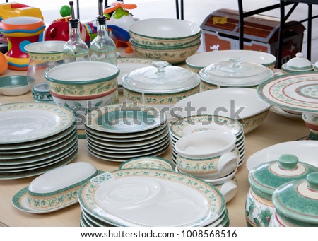 Collection of matching dishes and toys for sale at a garage sale Royalty-Free Stock Photo #1008568516