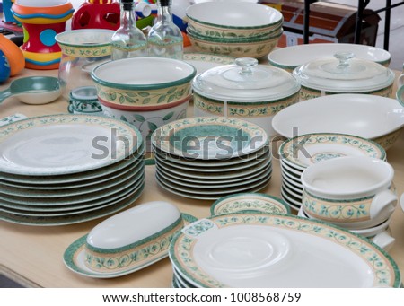 Collection of matching dishes and toys for sale at a garage sale Royalty-Free Stock Photo #1008568759