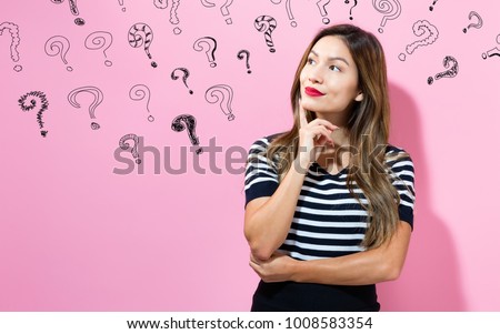 Question Marks with young woman in a thoughtful pose Royalty-Free Stock Photo #1008583354
